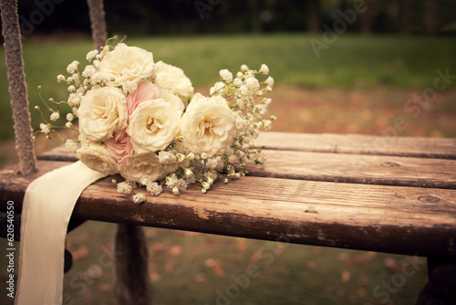 Pastel bridal flower bouquet on a wooden swing in an elegant vintage wedding style mood