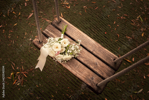 Pastel bridal flower bouquet on a wooden swing in an elegant vintage wedding style mood