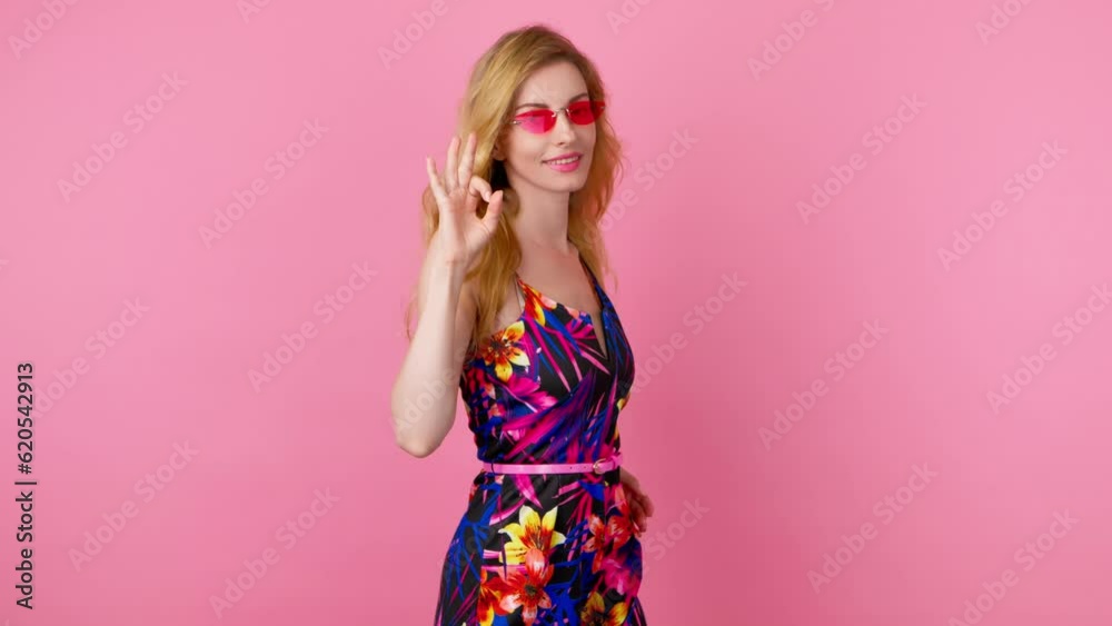 Woman fashionable, ok hand, wink and smile excited emotion, happy sign. Lady with emoji okay Yes gesture, mock up for success, approval, advertising, trendy makeup, floral outfit in studio on pink Woman fashionable, ok hand, wink and smile excited emotion, happy sign. Lady with emoji okay Yes gesture, mock up for success, approval, advertising, trendy makeup, floral outfit in studio on pink
