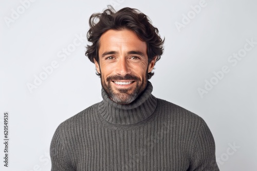 Portrait of a smiling man in sweater looking at camera over gray background photo