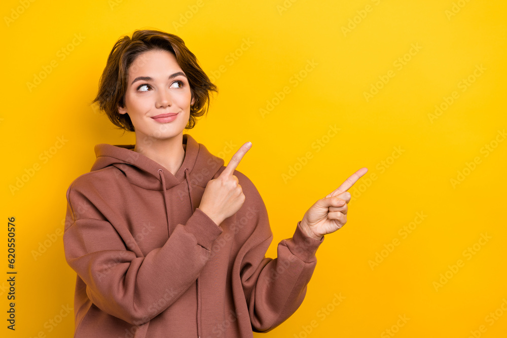 Photo portrait of pretty interested lady direct fingers empty space poster discount wear hood shirt isolated yellow color background Photo portrait of pretty interested lady direct fingers empty space poster discount wear hood shirt isolated yellow color background