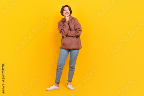 Full length portrait of lovely minded person hand touch chin look empty space isolated on yellow color background