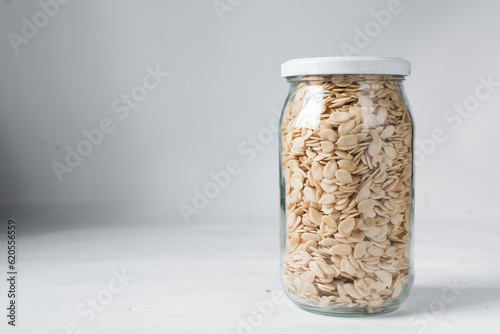 nigerian egusi seeds in a glass jar, shelled melon seeds in a transparent jar, nigerian melon seeds, pumpkin seeds for cooking photo