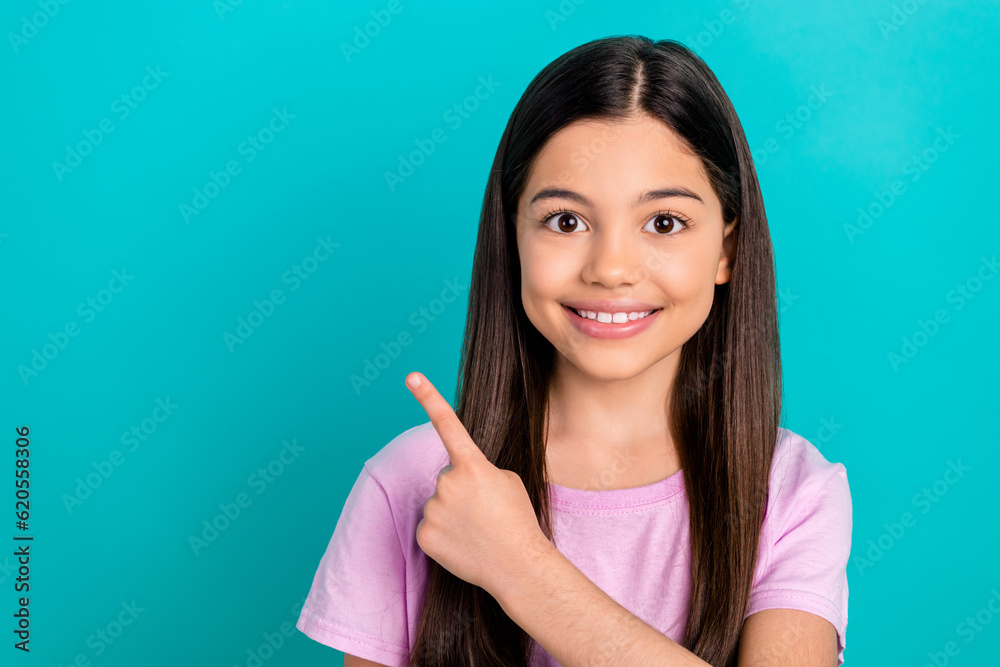 Photo of adorable positive small kid wear pink t-shirt pointing finger empty space isolated turquoise color background Photo of adorable positive small kid wear pink t-shirt pointing finger empty space isolated turquoise color background