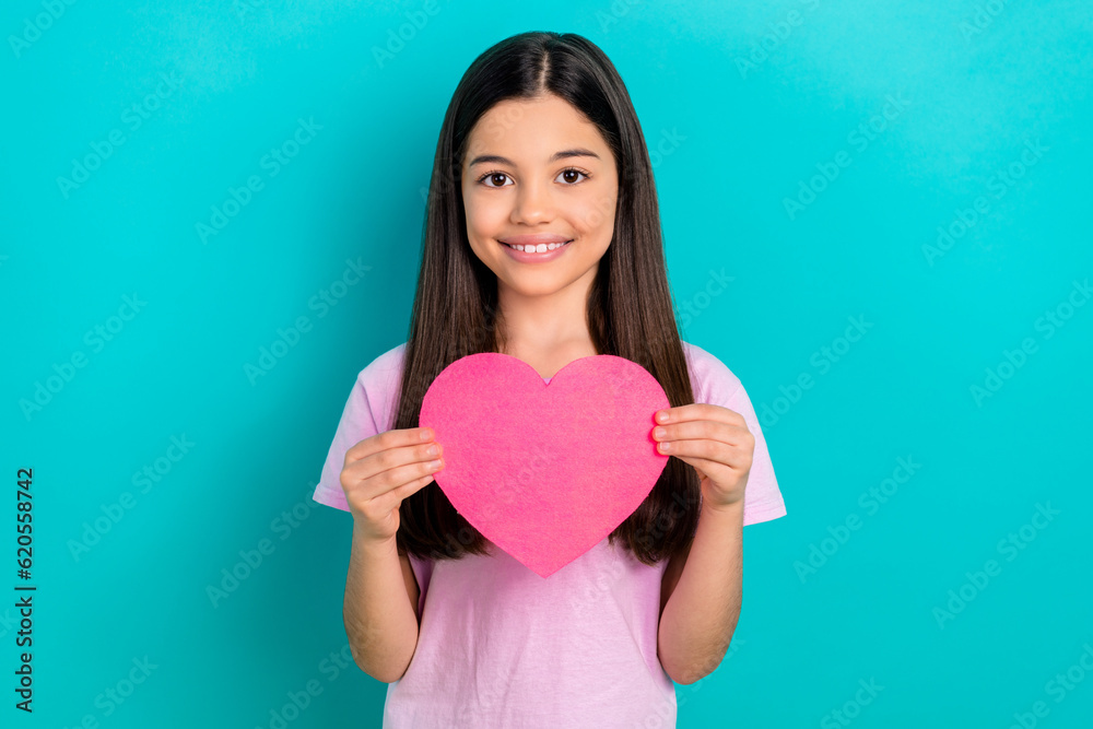 Photo of dreamy attractive little child dressed pink t-shirt rising paper heart isolated teal color background Photo of dreamy attractive little child dressed pink t-shirt rising paper heart isolated teal color background