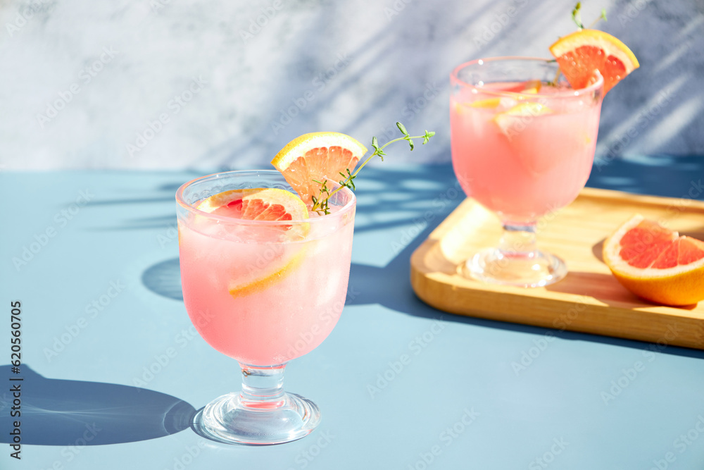 Summer chilled cocktails with citrus fruits. Drink with grapefruit or red orange and a sprig of thyme.