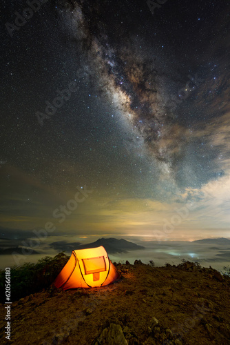 Yellow tent on top of mountain in night sky stars with Milky Way