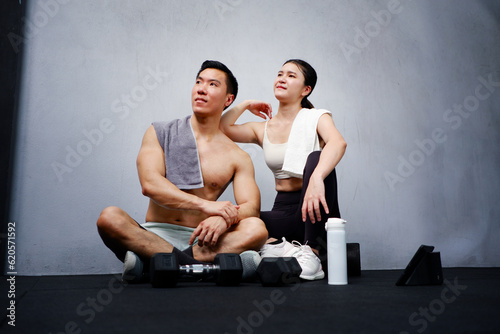 Young man and woman exercising in the gym fitness concept look and be healthy.