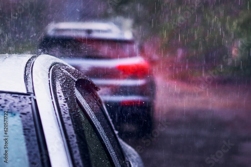 Fotografia Heavy rain falls on the roof of a car during a thunderstorm