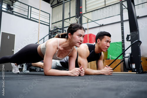 Young man and woman exercising in the gym. happy smile fitness concept.