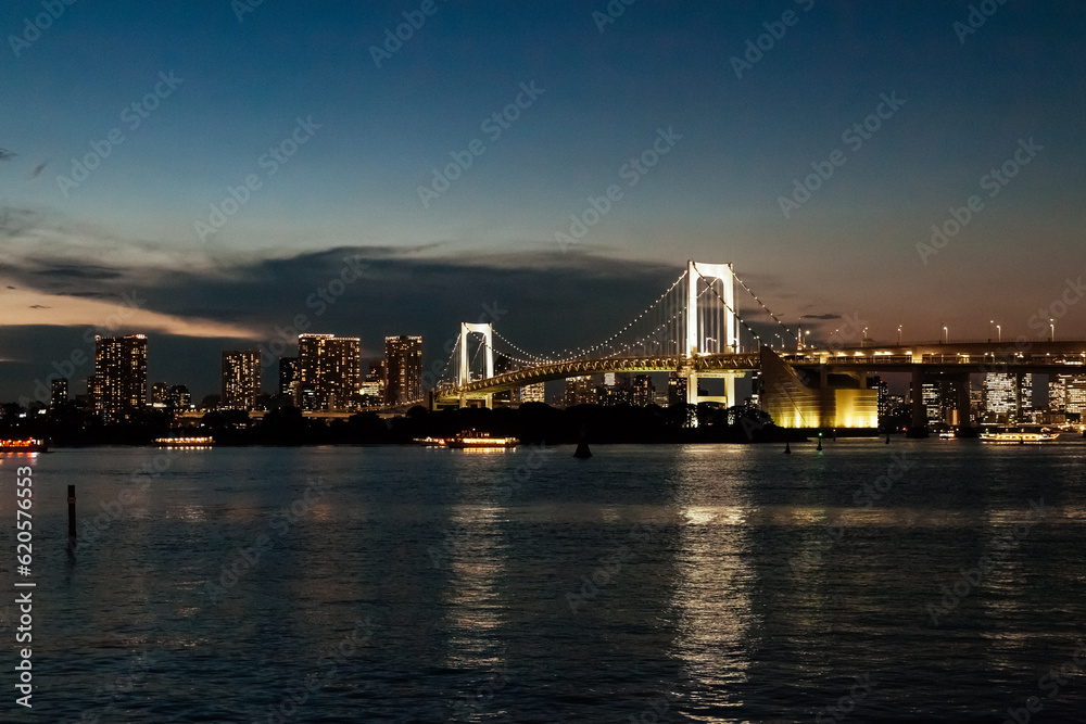 Illuminated Rainbow Bridge and Tokyo skyline at twilight with city lights reflecting on the water, perfect urban nightscape for travel, architecture, and lifestyle concepts Illuminated Rainbow Bridge and Tokyo skyline at twilight with city lights reflecting on the water, perfect urban nightscape for travel, architecture, and lifestyle concepts