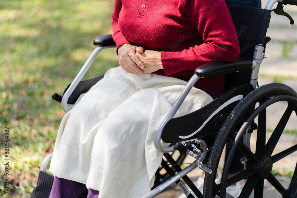 Obraz premium Nursing home. Young caregiver helping senior woman in wheelchair.