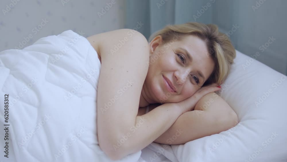 Beautiful woman lying in bed and smiling, enjoying her femininity and sensuality after good night with man, date Beautiful woman lying in bed and smiling, enjoying her femininity and sensuality after good night with man, date