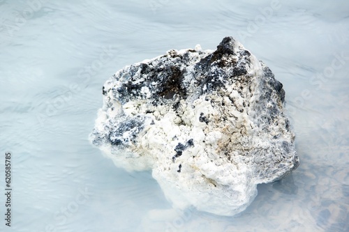 Obraz na płótnie Black rock in milky white waters of Icelandic thermal nature baths near blue lagoon w salonie