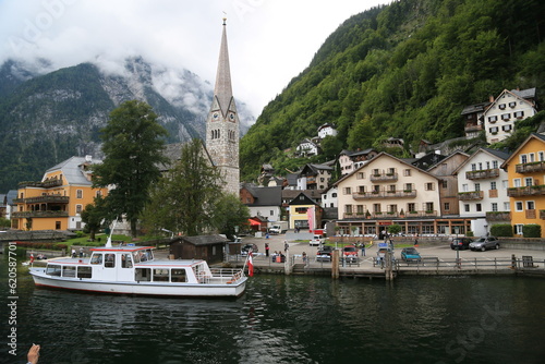 Photo of a serene lakeside town with colorful buildings and boats on the water, Austria © Foto