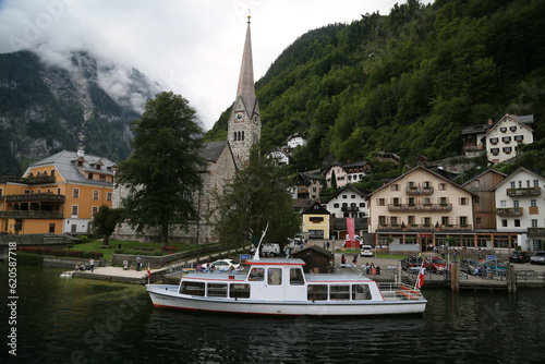 Photo of a serene lakeside town with colorful buildings and boats on the water, Austria