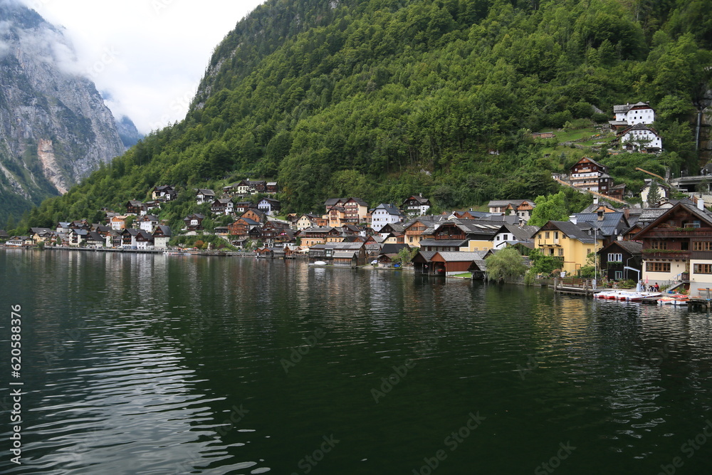 Photo of a serene lakeside town with colorful buildings and boats on the water, Austria