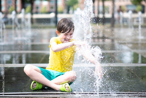 happy boy playing in dry fountain in summer