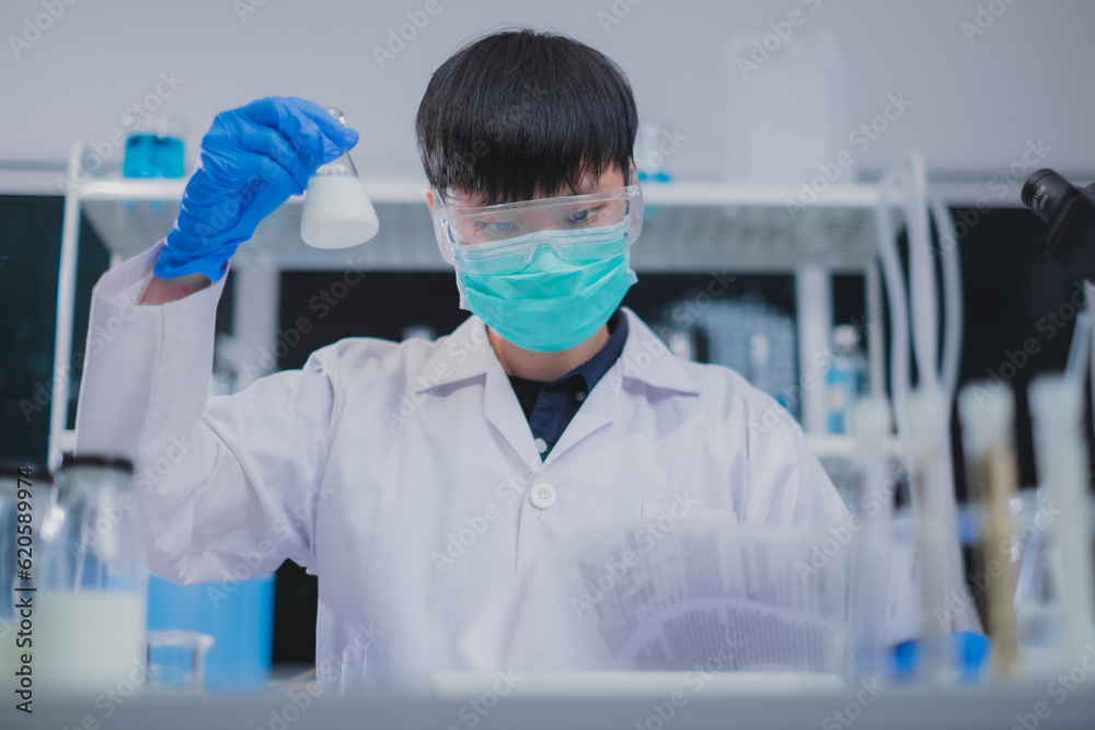 Nutritionist or scientist is checking and holding a sample of milk in test tube. Concept of nutrition, lactose, protein, bacteria, fat and glucose laboratory. Dairy milk test, research or analysis. Nutritionist or scientist is checking and holding a sample of milk in test tube. Concept of nutrition, lactose, protein, bacteria, fat and glucose laboratory. Dairy milk test, research or analysis.