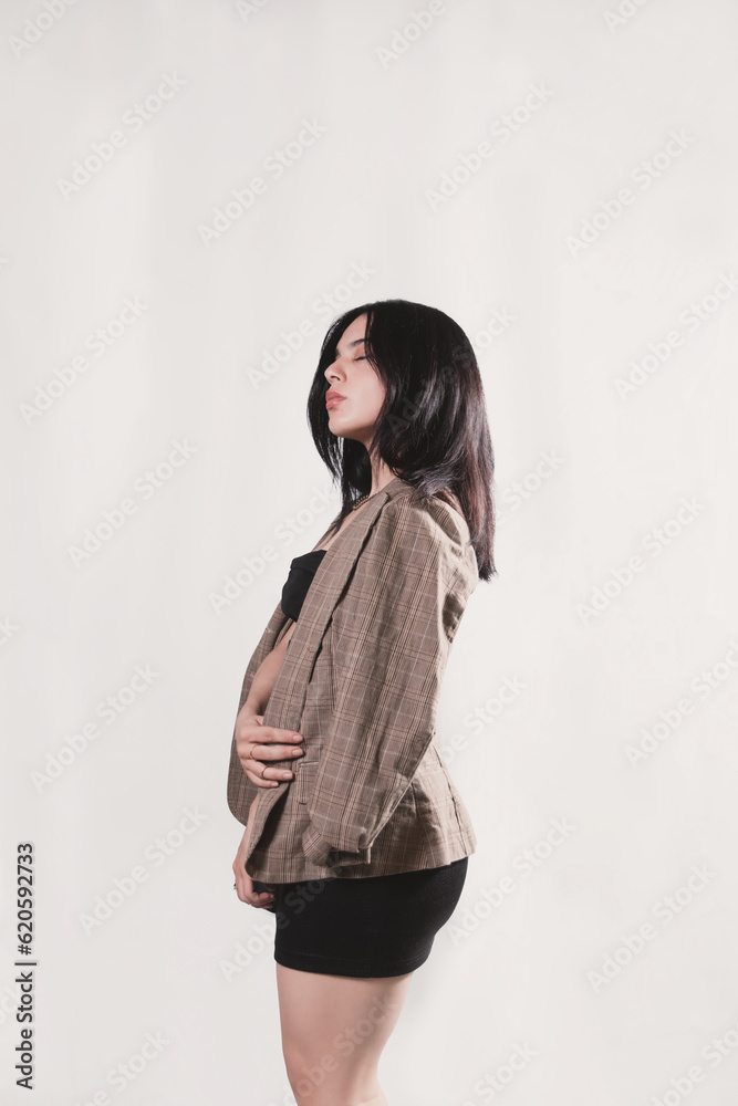 Elegant beautiful young girl in black dress and blazzer posing sideways on white background. Elegant beautiful young girl in black dress and blazzer posing sideways on white background.