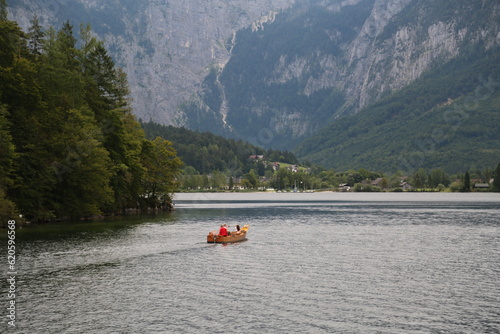 A man peacefully rowing a small boat on a lake, Austria