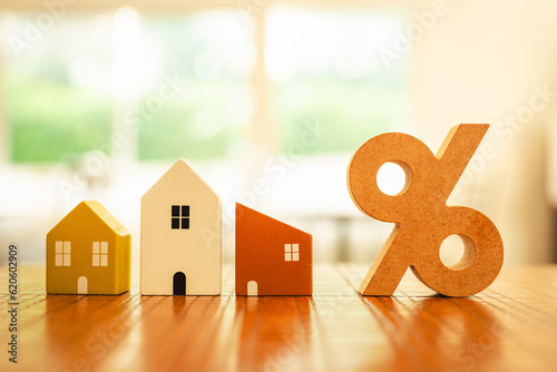 Percentage and house sign symbol icon wooden on wood table. Concepts of home interest, real estate, investing in inflationม home loan interest rate hike.	
 photo