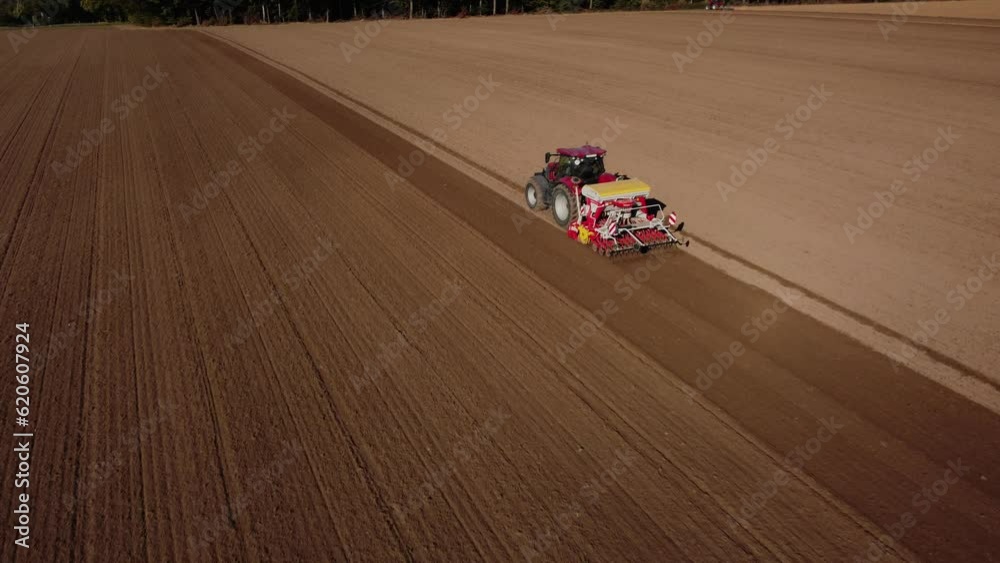 red tractor plows the ground in autumn, agricultural machinery at work red tractor plows the ground in autumn, agricultural machinery at work