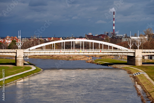 Steel structure of the bridge over the Warta River and smoke from an industrial chimney in Poznan