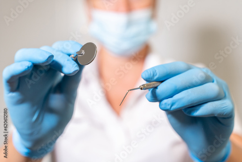 Dentist examining oral cavity mouth of the patient in dental chair with mirror and tools in medical office. Hygiene and health of oral teeth. Patient perspective