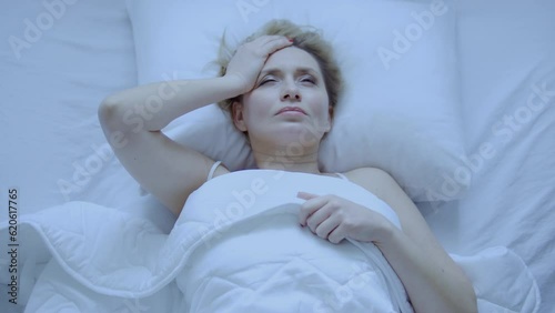 Woman sleep in cheap hotel room and suffering headache because of stuffiness