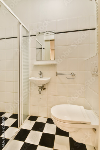 a bathroom with black and white checkered tiles on the floor  shower stall and toilet in the corner area