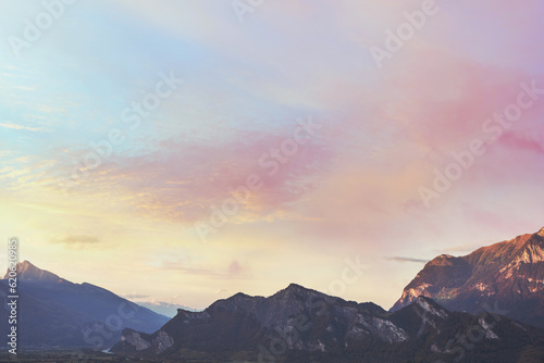 Silhouette of mountain at sunset pastel orange, pink, blue sky and clouds. © flowertiare