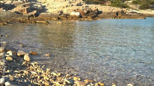 Coast of the sea with emerald water. Calm summer evening. Sunset