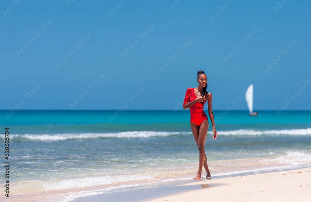 Portrait of Beautiful Caribbean Adult Teen in Barbados. Wearing Red Bikini and Walking on a tropical beach. Caribbean Sea in Background. Black. Portrait. Portrait of Beautiful Caribbean Adult Teen in Barbados. Wearing Red Bikini and Walking on a tropical beach. Caribbean Sea in Background. Black. Portrait.