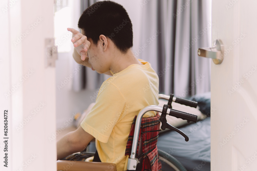 Hand of Young man using his arm to wipe tears,Teenage boy in bedroom, view through room door in Healthcare,Mental health affected during the quarantine,Sad emotional,loneliness,depression concept.