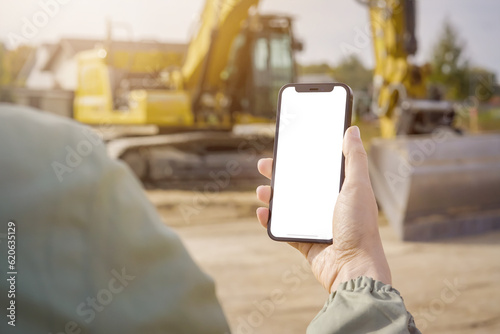 Construction Management in Action: Person Holding White Screen Smartphone on Site