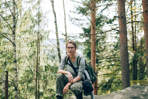 The girl is sitting on a stone in the wood