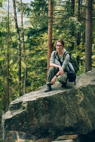 The girl is sitting on a stone in the wood