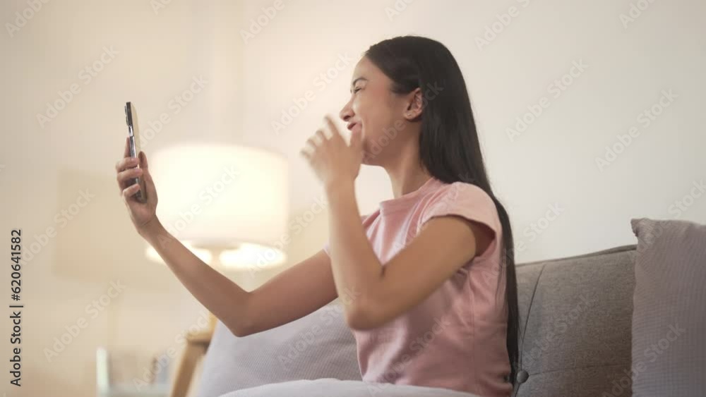 Happy asian woman using mobile phone for video conference at home. Happy asian woman using mobile phone for video conference at home.