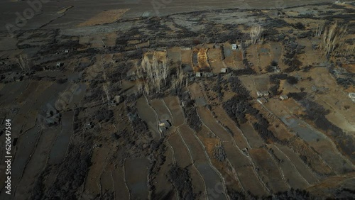 Aerial orbit landscape shot of cultivated land and houses at remote Zarabod Village near Hussain suspension bridge. Zarabod is a small agricultural hamlet in Gojal Hunza in Gilgit-Baltistan, Pakistan photo