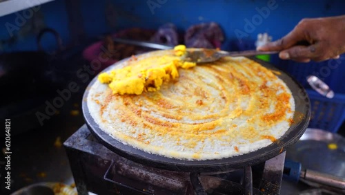 Indian Dosa street food slow motion stock footage Spreading hot chili potato stuff on famous Indian food dosa while making dosa on a hot gas stove, slow motion stock footage photo