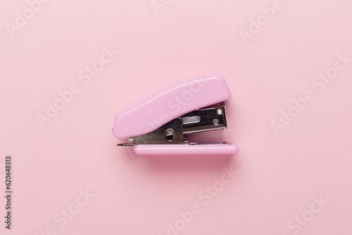 Pink stapler on color backgroung, top view photo