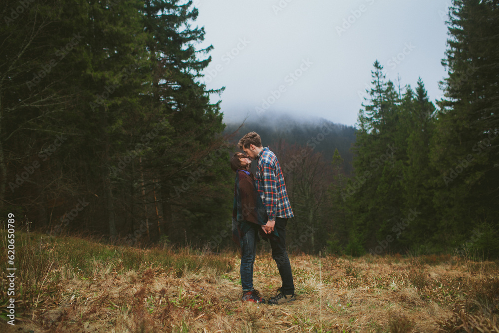 Man and woman kissing on the background of the forest in mist Man and woman kissing on the background of the forest in mist