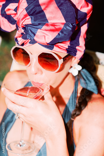 fashionable extravagant woman sips cocktail  photo