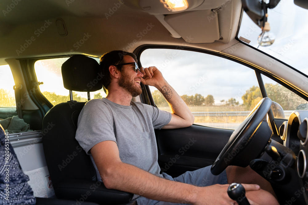 Man driving a car at sunset Man driving a car at sunset