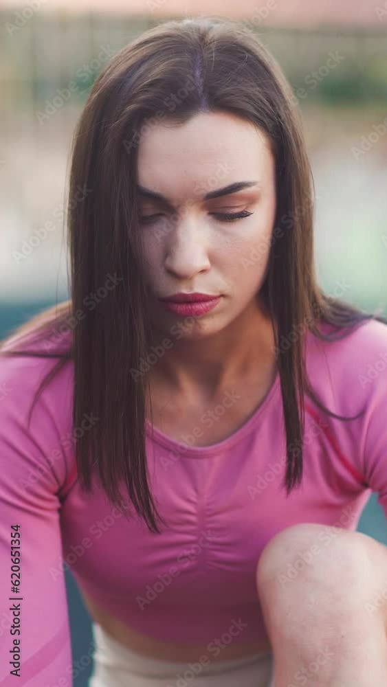 Vertical video. Young motivated girl is preparing to run stadium in summer, heathy lifestyle, sport conception. Portrait of a girl runner before the race Vertical video. Young motivated girl is preparing to run stadium in summer, heathy lifestyle, sport conception. Portrait of a girl runner before the race