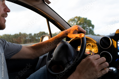 Man driving a car at sunset