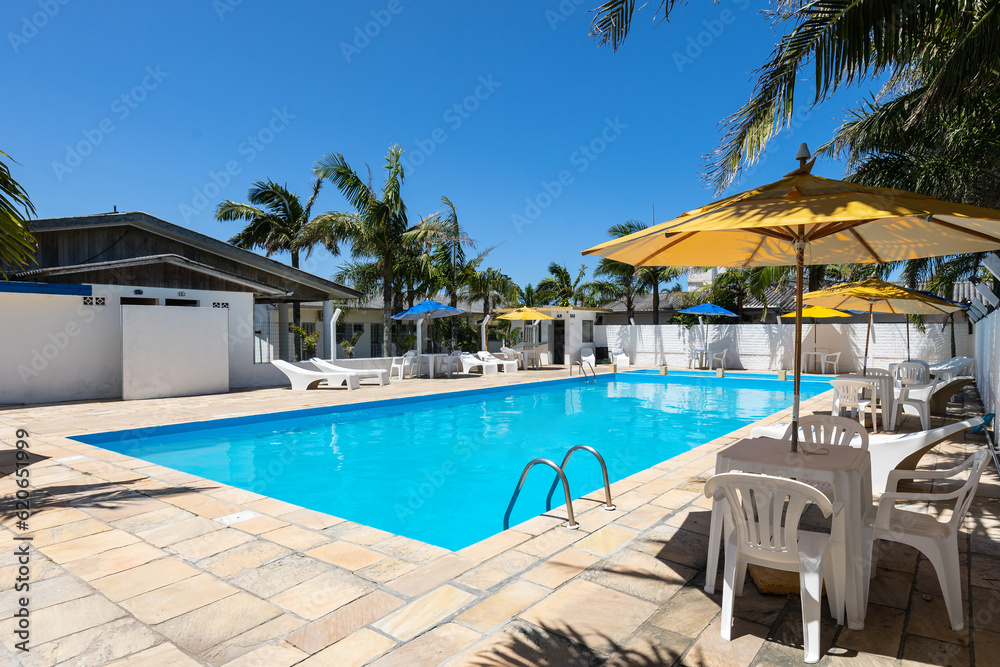 Swimming pool and lounge area with hammocks, tables and beach umbrella Swimming pool and lounge area with hammocks, tables and beach umbrella