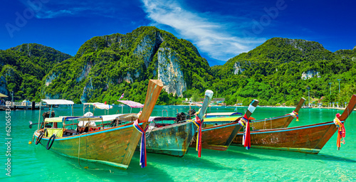 koh phi phi thailand with long tail boats floating on crystal clear water