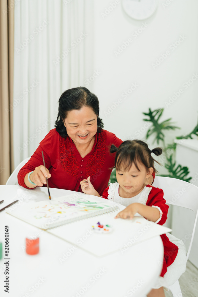 Happy grandmother and a little girl painting Happy grandmother and a little girl painting